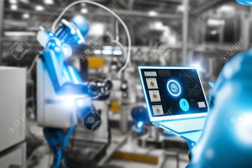Trabalhadores da fábrica que trabalham com o braço robótico adepto em uma oficina. Software de programação do robô da indústria para a tecnologia de fabricação automatizada.