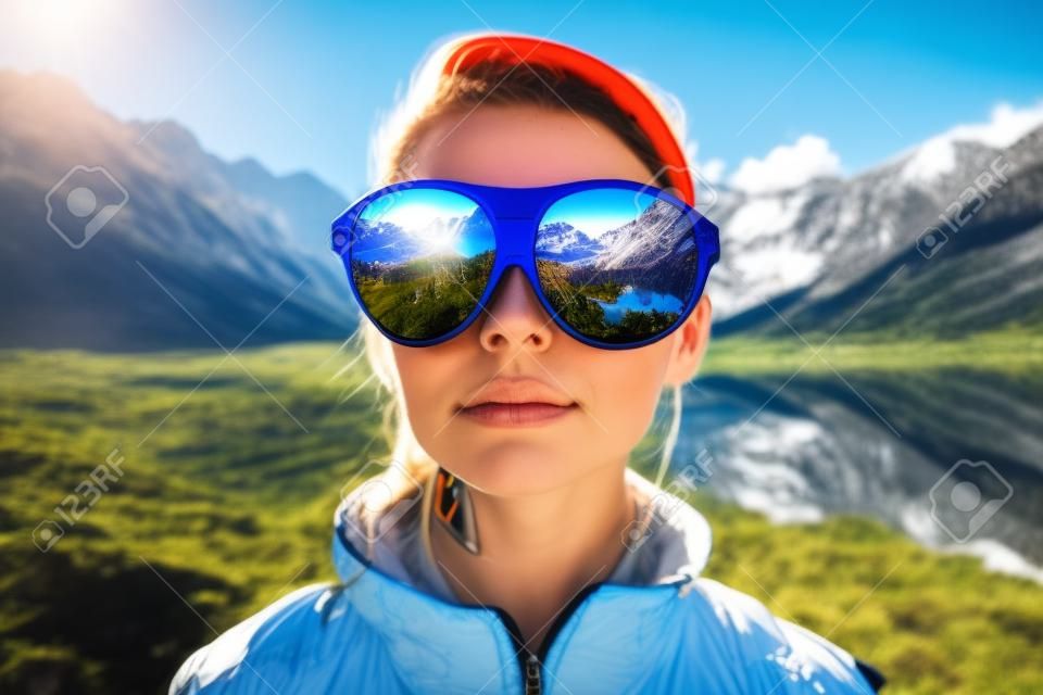 Os óculos de sol espelhavam o reflexo do maravilhoso caminho da montanha e o céu ensolarado retratado pela mulher caminhante em um conceito natural de aventura e exploração da natureza por IA generativa.
