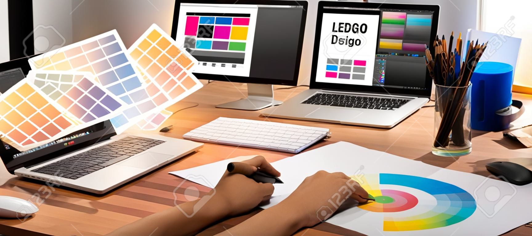 El diseñador gráfico trabaja en una computadora portátil y con un lápiz de dibujo gráfico mientras realiza una lluvia de ideas sobre un diseño único con un equipo gráfico profesional en un moderno estudio digital en el lugar de trabajo.