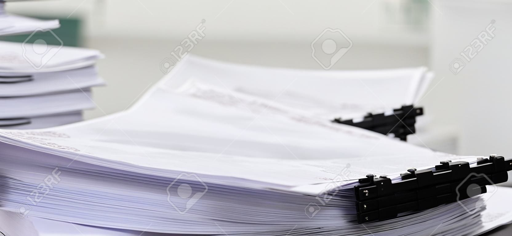 Stół biurowy w zbliżeniu z uporządkowanymi ułożonymi papierami jako koncepcja zorganizowanego systemu zarządzania dokumentami dla zapracowanych raportów biznesowych lub równości dokumentów prawnych