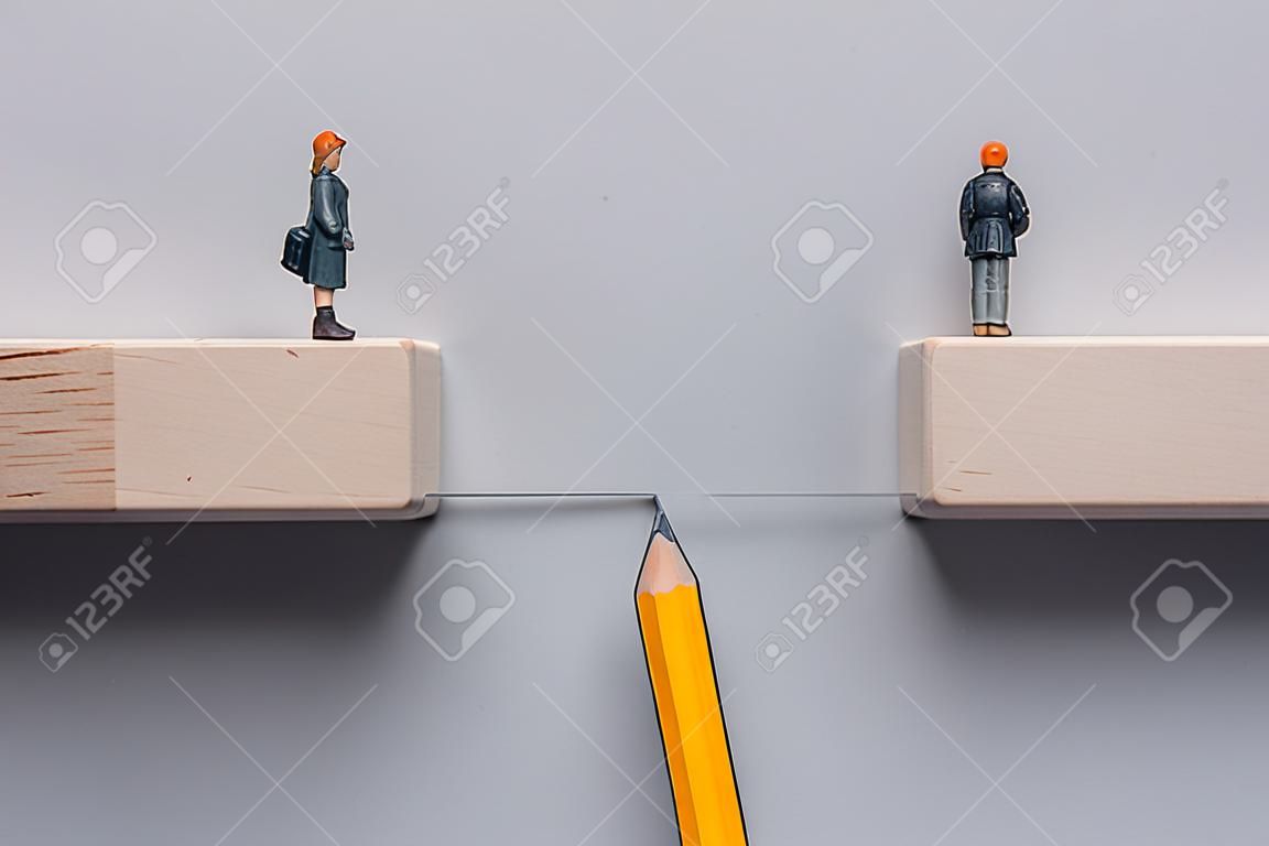 Bleistiftskizze, die die Lücke zwischen Holzblöcken überbrückt, damit die weibliche Miniaturfigur sie überqueren kann