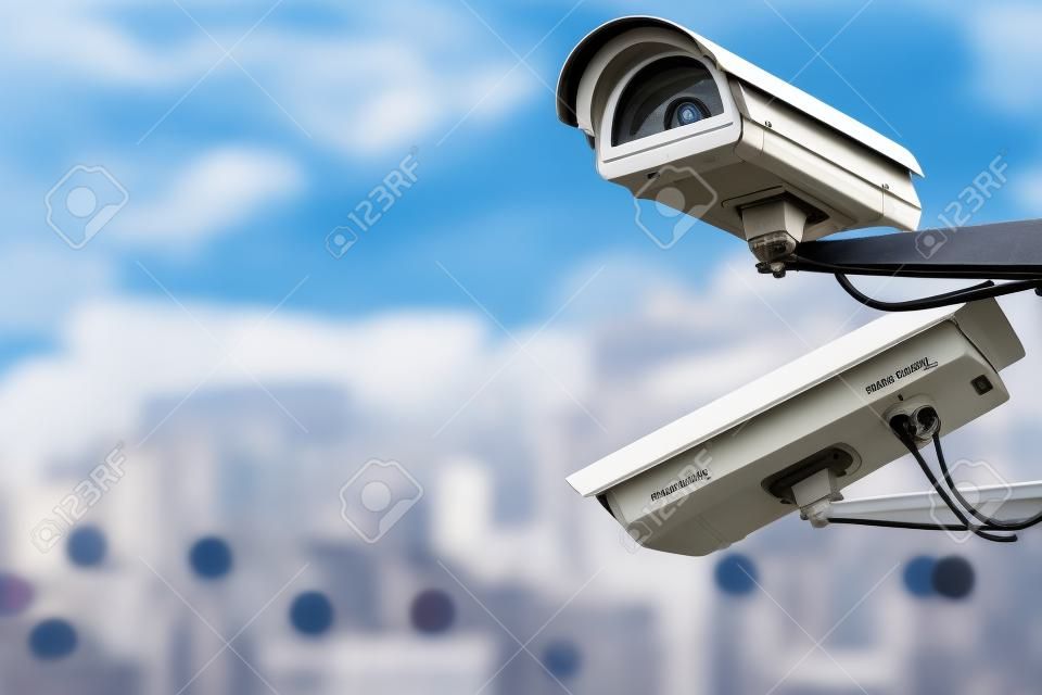 Concentre-se no sistema de monitoramento de câmera CCTV de segurança com vista panorâmica de uma cidade em fundo desfocado