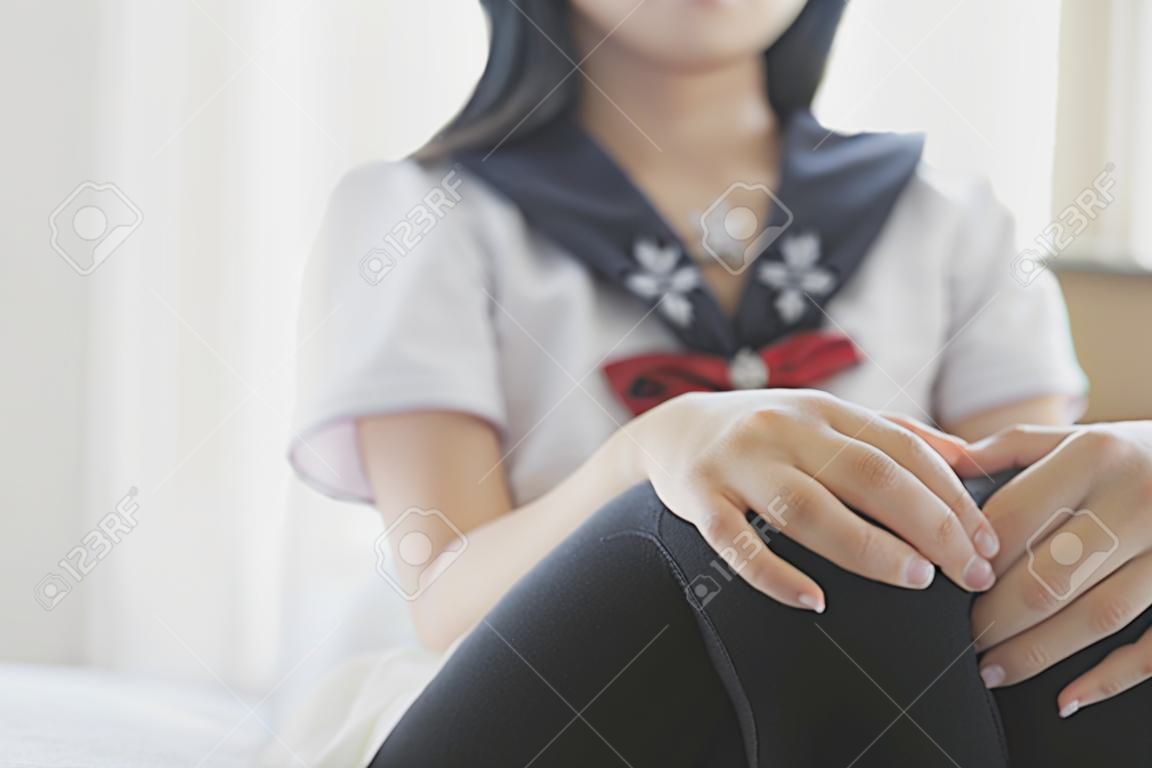Portrait de fille de l'école japonaise chemin du corps dans la chambre à coucher de ton blanc