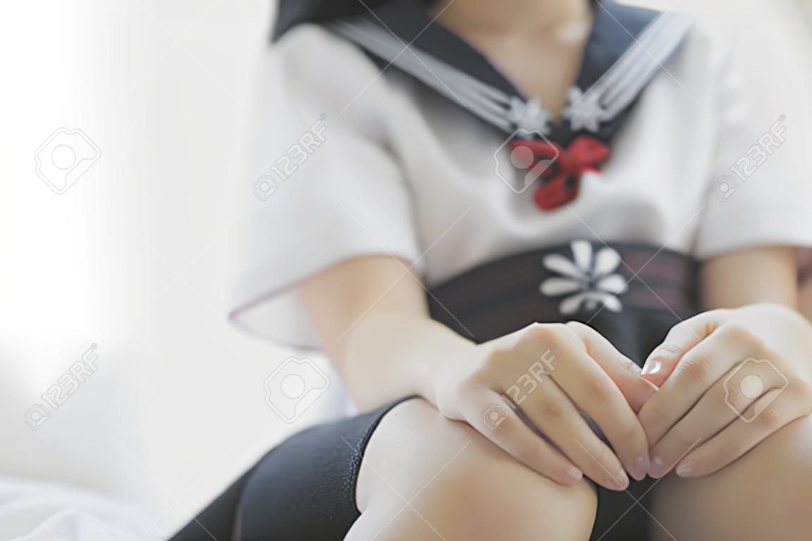 Retrato japonês escola menina caminho do corpo no quarto de cama tom branco