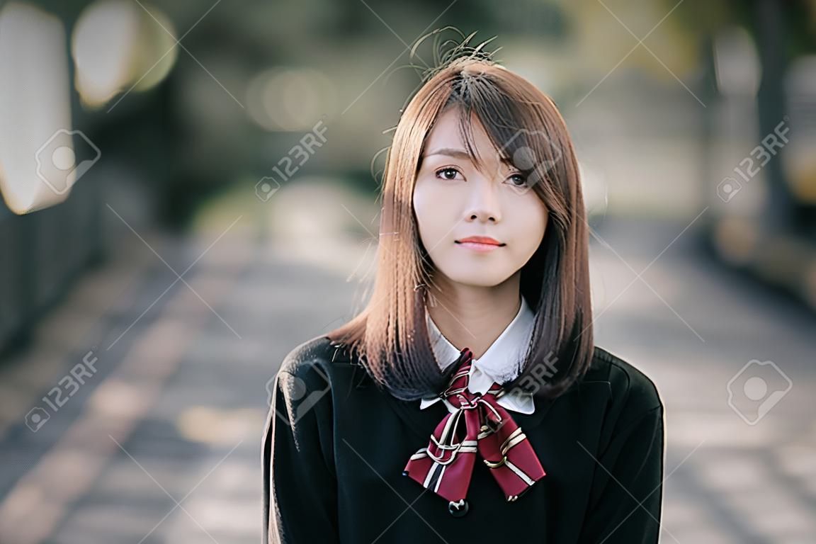 公園屋外映画ヴィンテージスタイルを見てアジアの日本の女子校生の衣装の肖像画