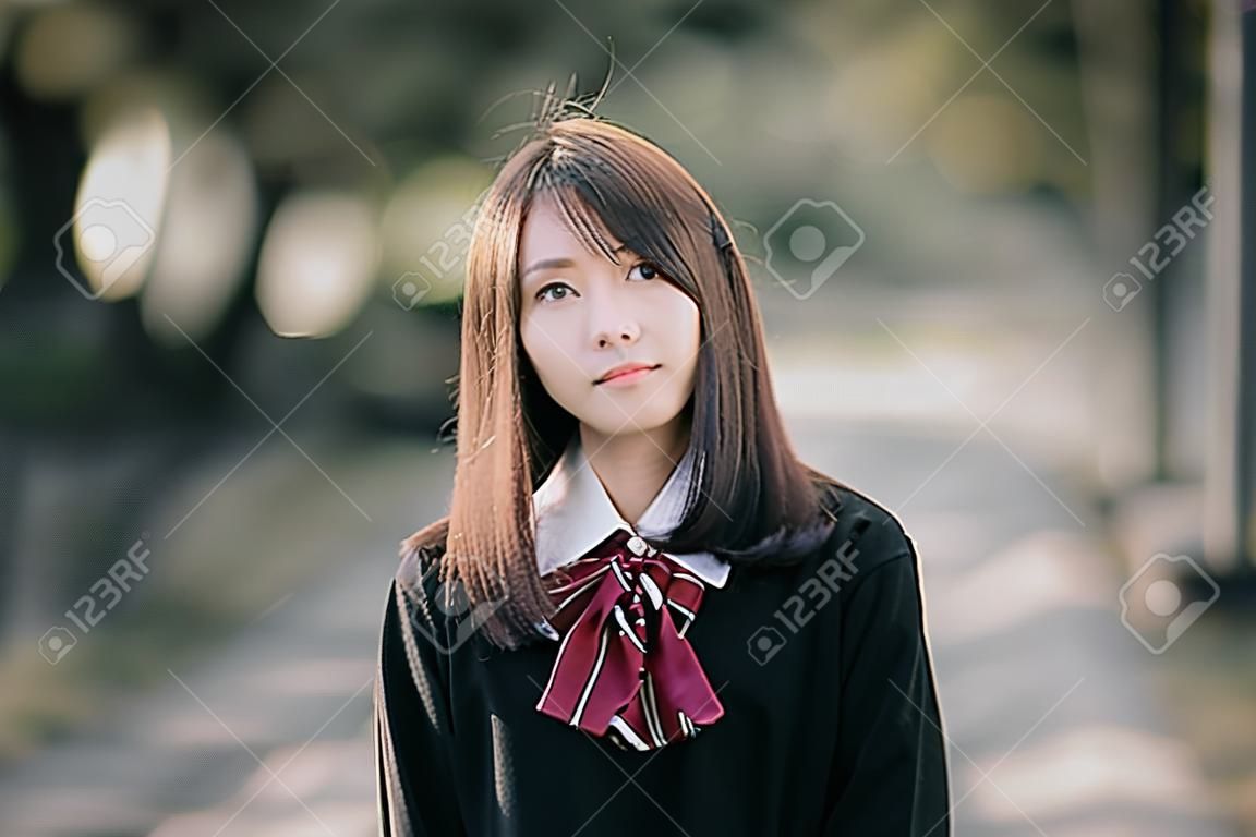 公園屋外映画ヴィンテージスタイルを見てアジアの日本の女子校生の衣装の肖像画