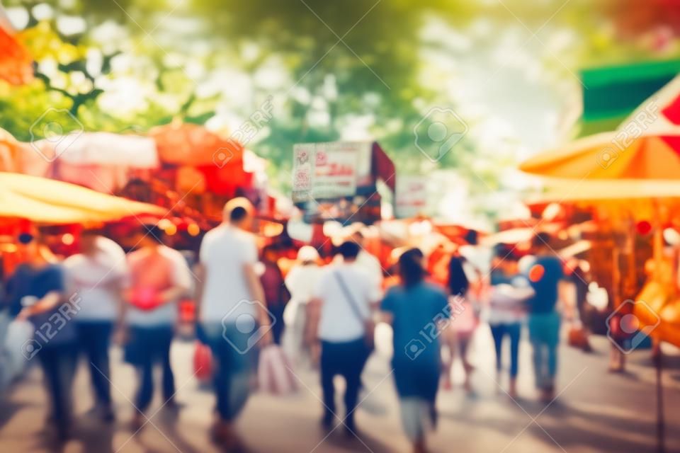 Abstrakte unscharfe Touristeneinkäufe auf dem Wochenendmarkt Chatuchak im Freien am sonnigen Tag Bangkok Thailand Hintergrund - Vintage-Filtereffekt