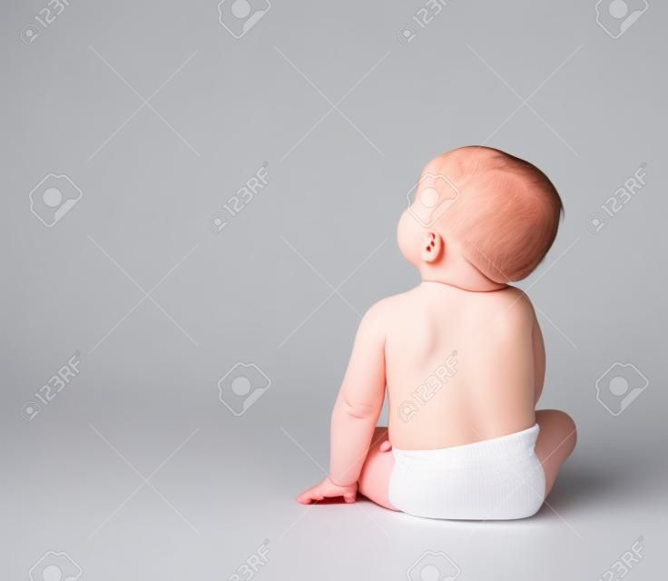 bambin bébé assis face à l'arrière isolé sur un fond blanc