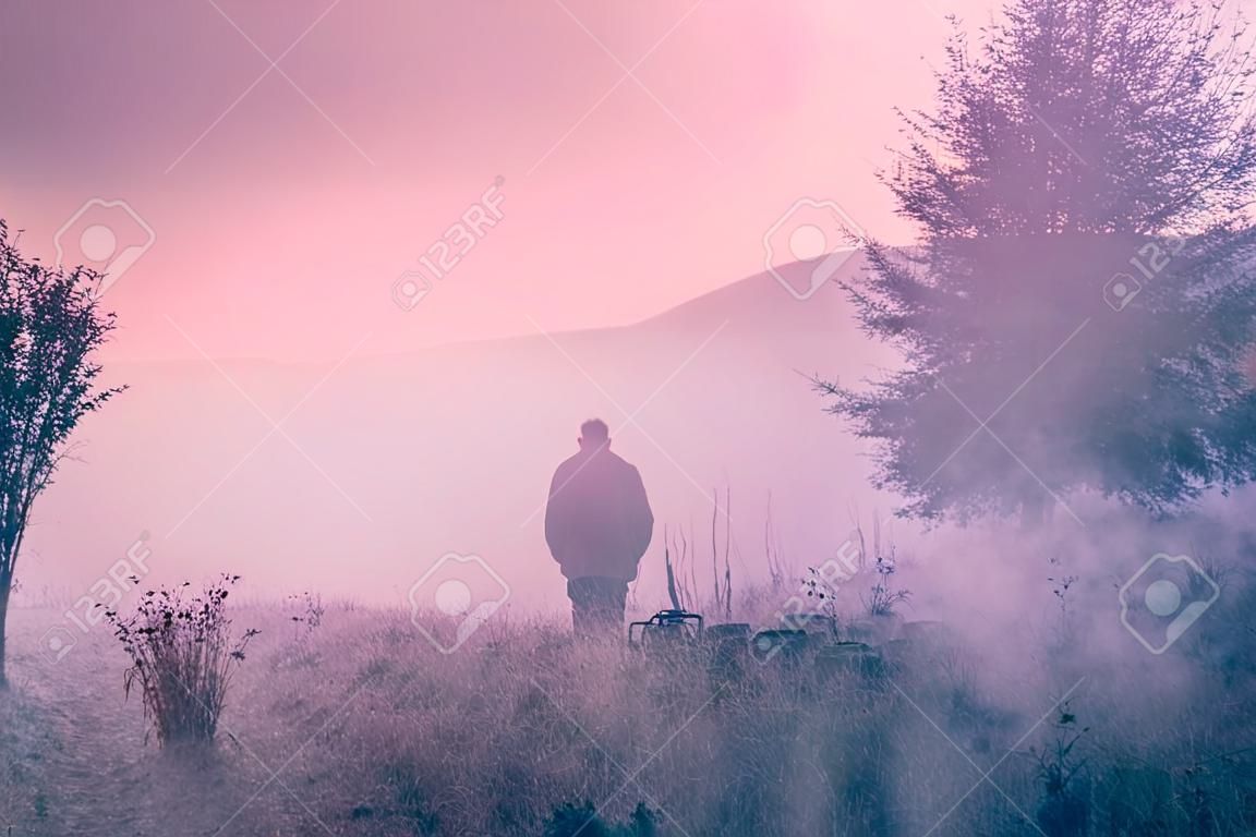 Одинокий человек в утреннем тумане ландшафтной композиции