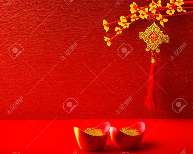 Decoración de año nuevo chino sobre un fondo rojo Flores de buena fortuna y terrón de oro.