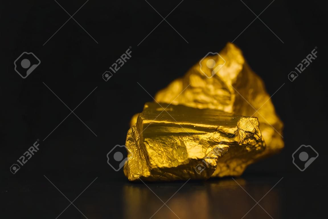 Primer plano de pepita de oro o mineral de oro sobre fondo negro, piedra preciosa o trozo de piedra dorada, idea de concepto financiero y empresarial.