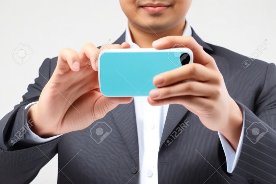 Hombre de negocios asiático con una cámara móvil en el fondo blanco