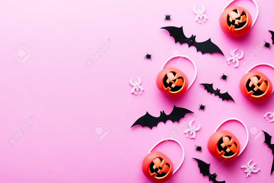 Decorações do Dia das Bruxas no fundo cor-de-rosa pastel. Conceito do Dia das Bruxas. Lay liso, vista superior, espaço da cópia
