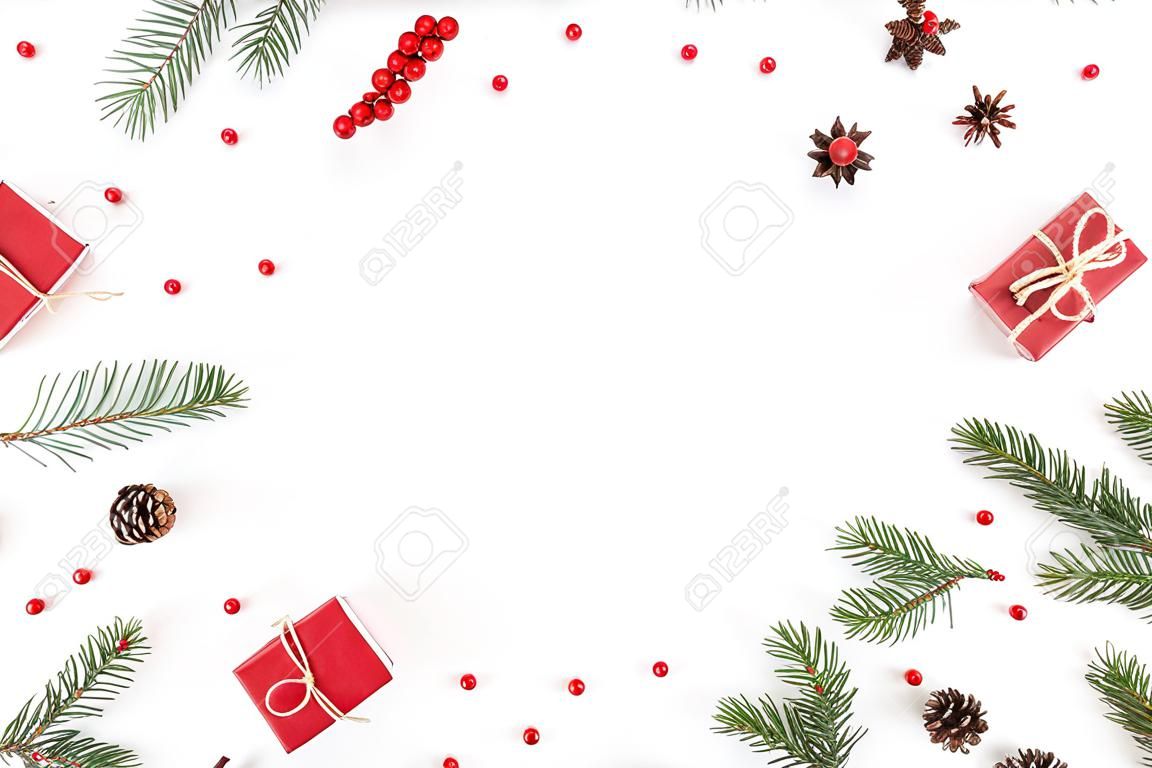 Ramka na kompozycję bożonarodzeniową wykonana z prezentów świątecznych, gałęzi sosny, zabawek na białym tle, płasko ułożona, widok z góry, przestrzeń kopiowania