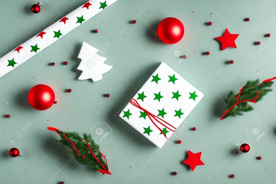 Weihnachtskomposition. Weihnachtsgeschenk, Tannenzweige, rote und grüne Dekorationen auf weißem Hintergrund. Flache Lage, Draufsicht