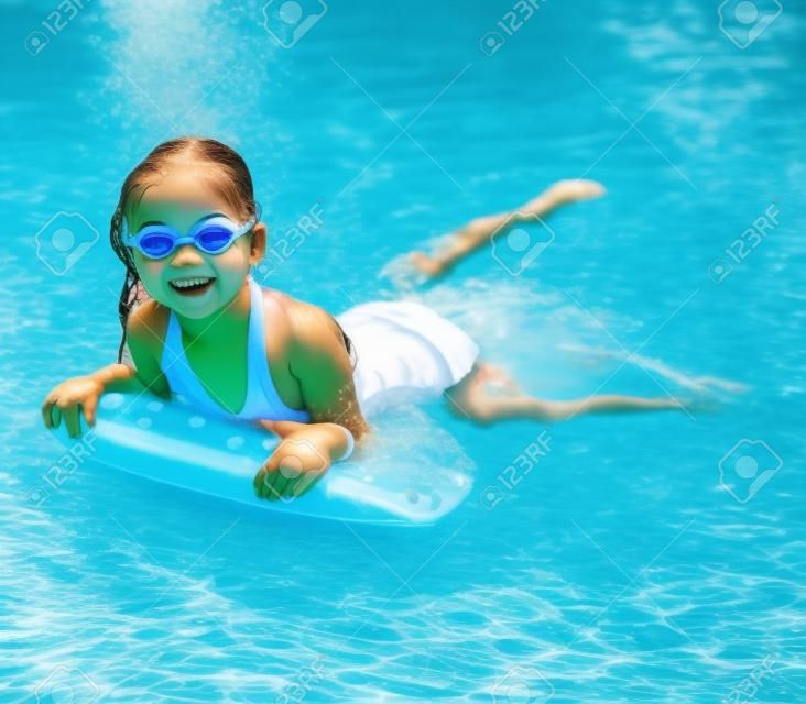 Bambina in piscina. Estate all'aperto.