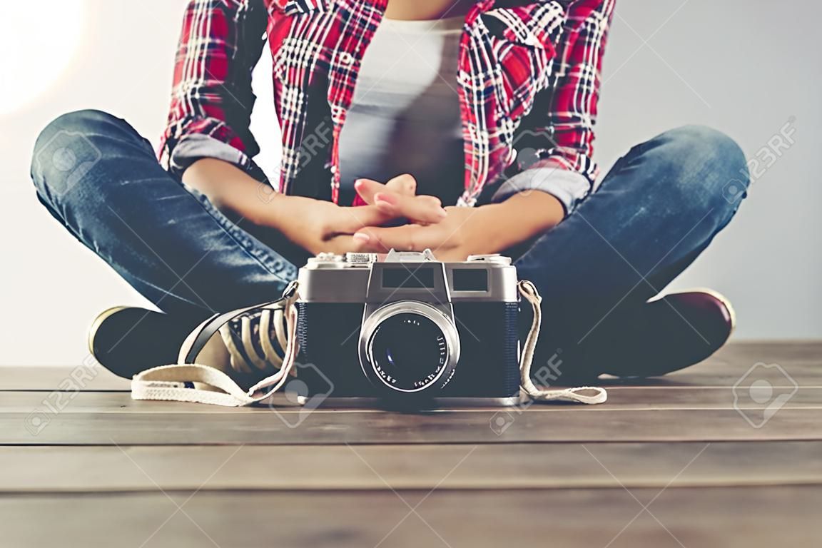 Young beautiful hipster woman with an old retro camera.
