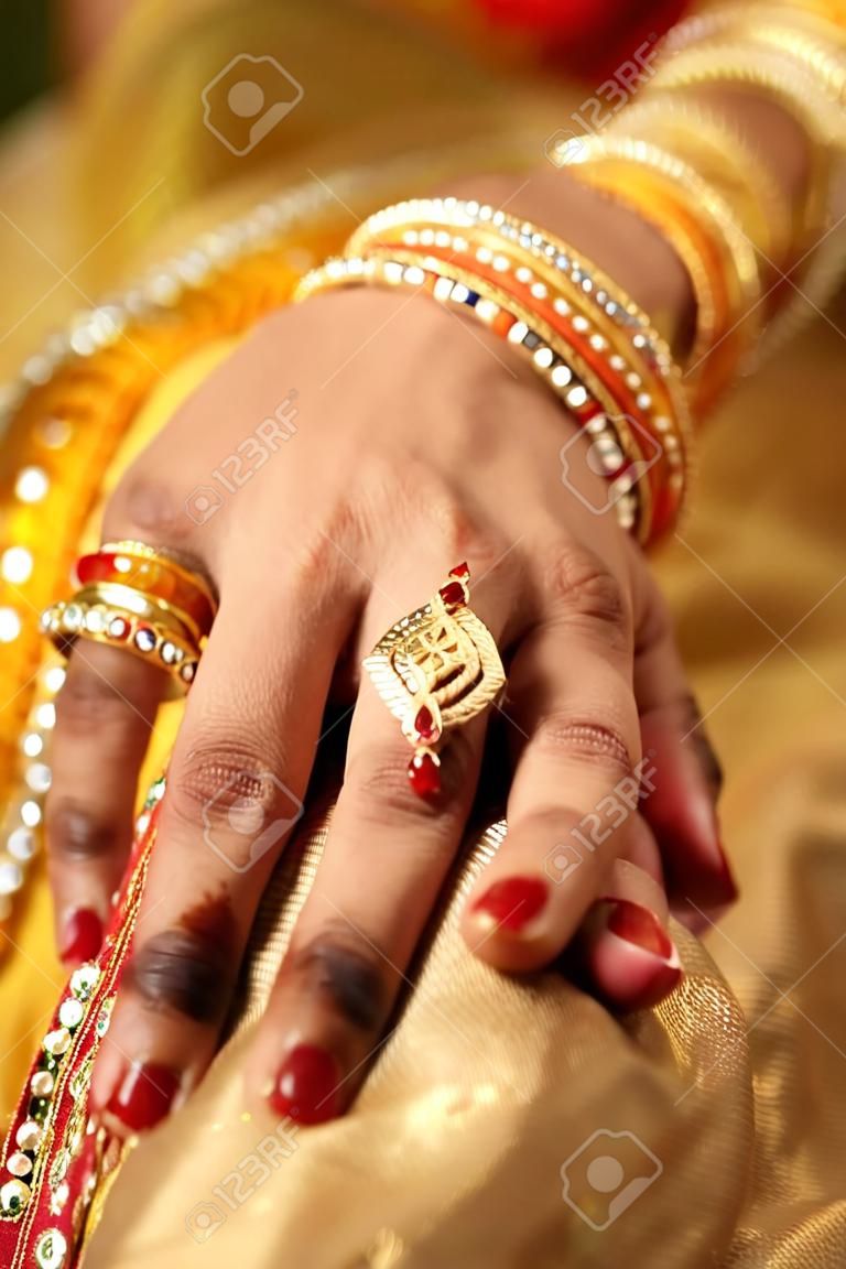 dettaglio mano di sposa indiana con il braccialetto decorativo e anello d'oro