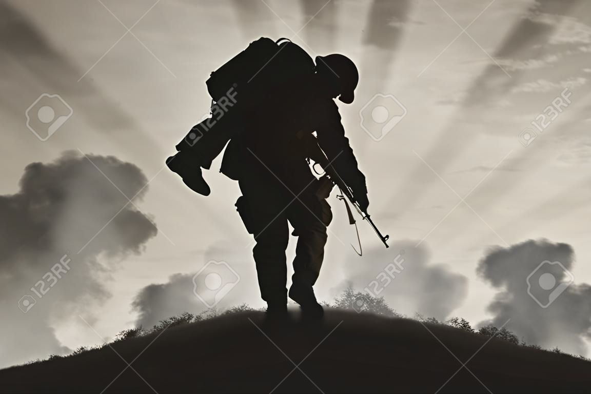 Savaş ve çatışma kavramı. Asker duman gökyüzünde bir arka plan üzerinde yaralı bir asker taşır