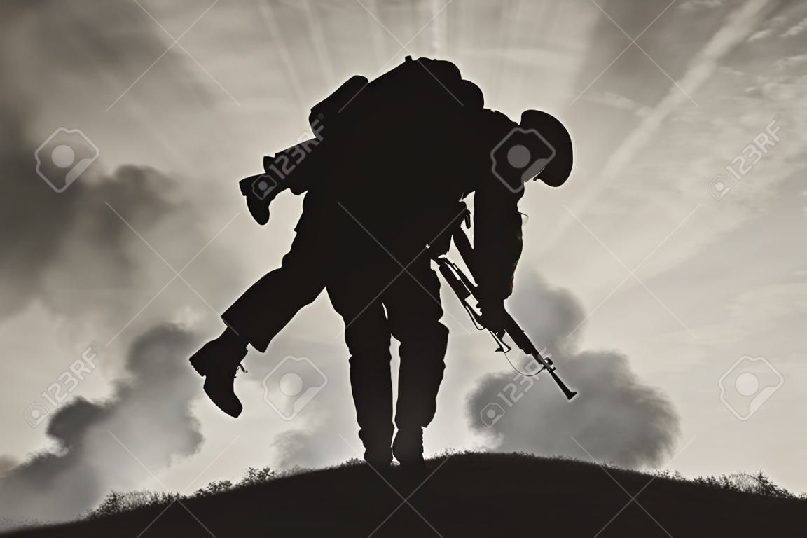 Oorlog en conflict concept. Soldaat draagt een gewonde soldaat op een achtergrond van de lucht in rook
