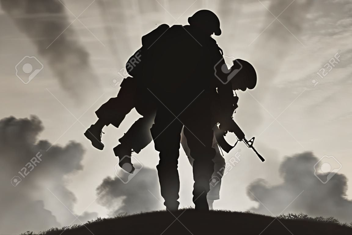 戰爭與衝突的概念。士兵在煙霧瀰漫的天空背景上載著一名受傷的士兵