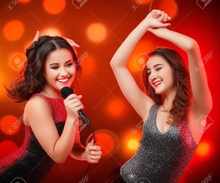 Dos hermosas chicas jóvenes bailando y cantando