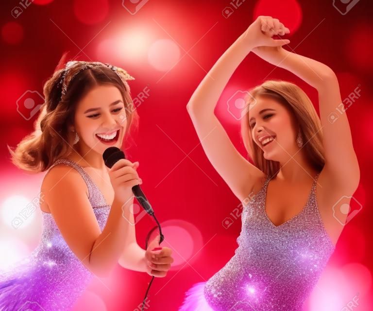 Dos hermosas chicas jóvenes bailando y cantando