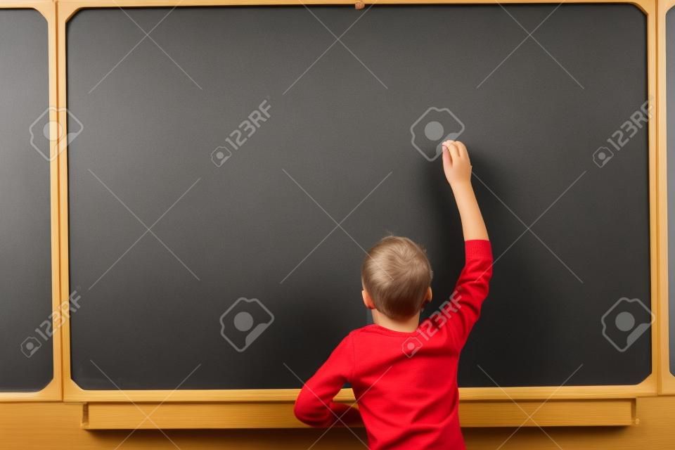 Photo of smart pupil going to write something on blackboard