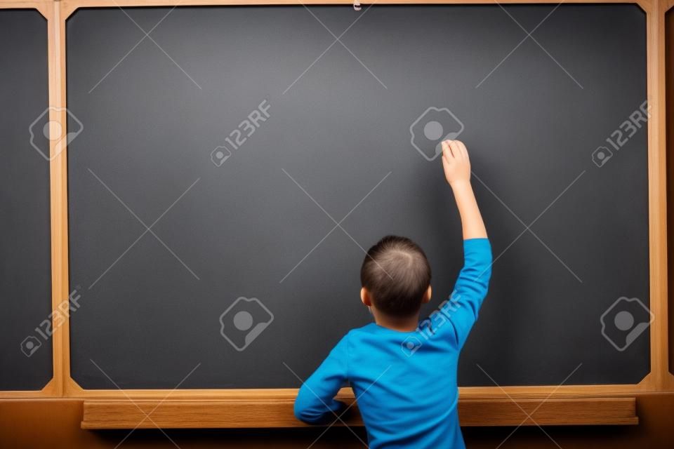 Photo of smart pupil going to write something on blackboard