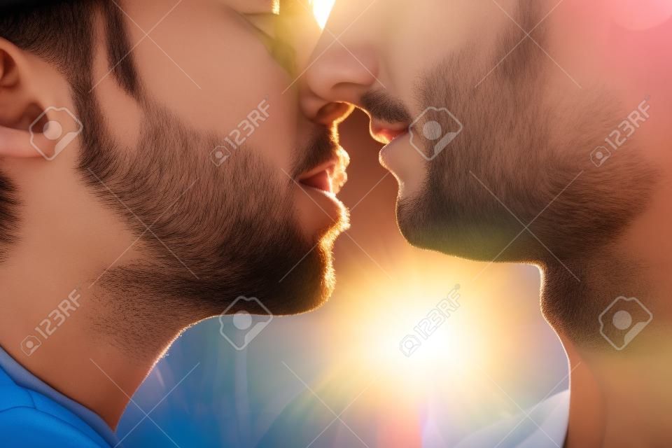 Крупным планом молодых людей целоваться против солнца