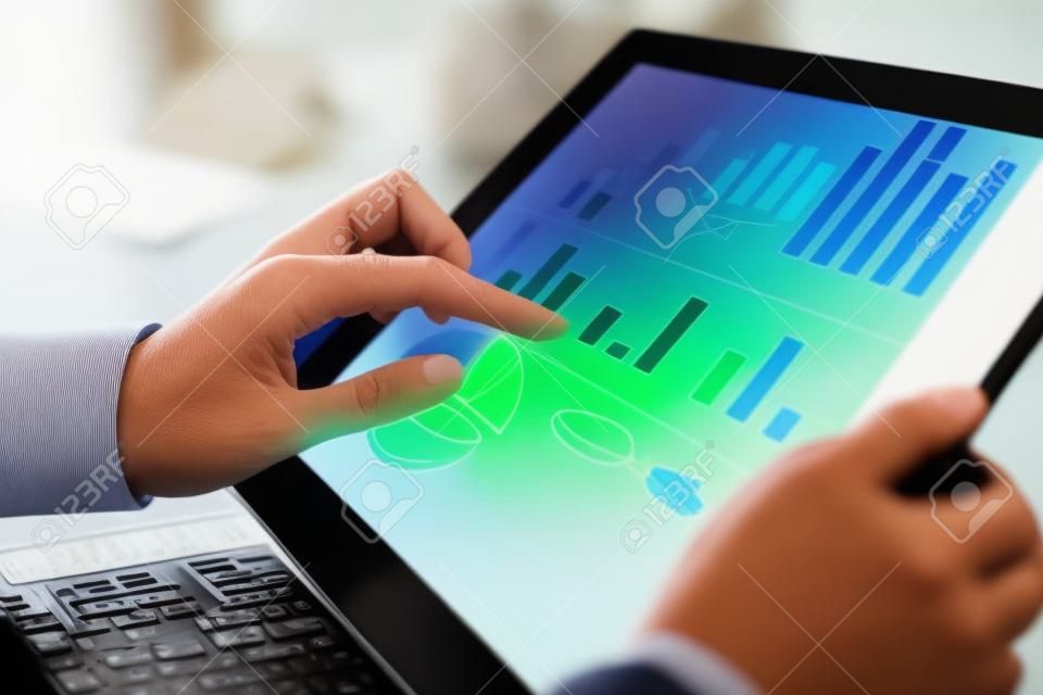 Close-up beeld van een kantoormedewerker met behulp van een touchpad om statistische gegevens te analyseren