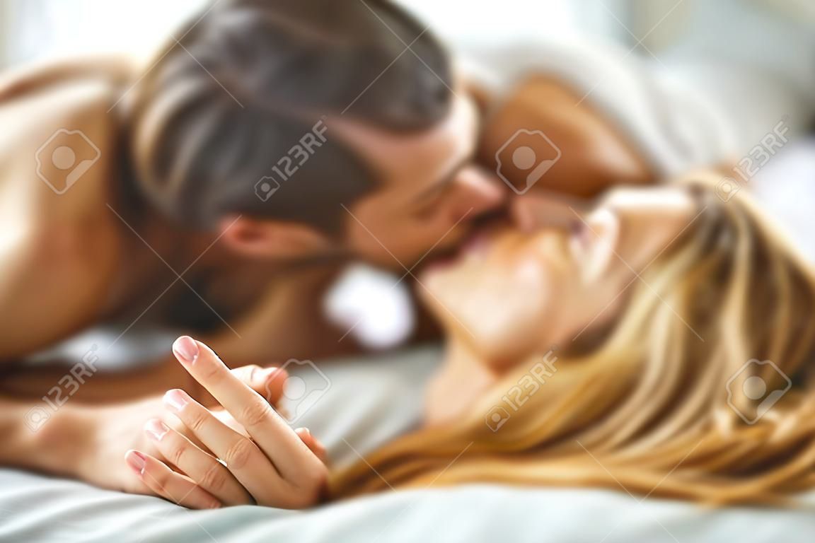 Coppia che si bacia appassionatamente a letto