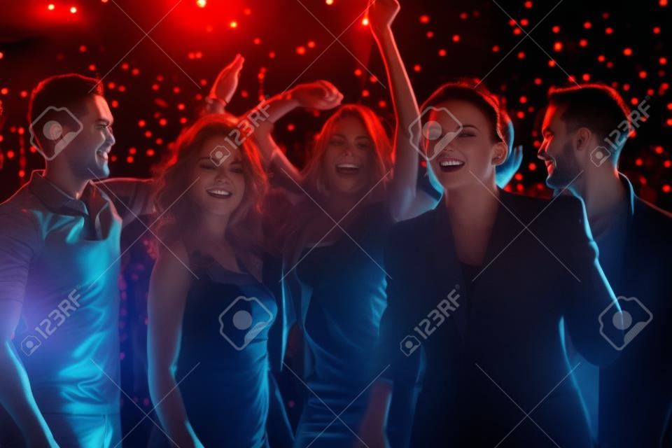 Grupa chłopaków i dziewcząt tańczących w nocnym klubie