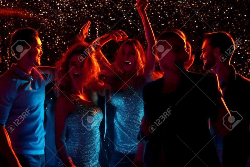 Grupa chłopaków i dziewcząt tańczących w nocnym klubie