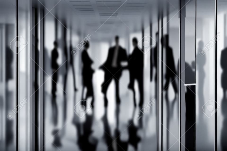 Silhouetten von Geschäftspartnern interagieren im Korridor des Business-Center