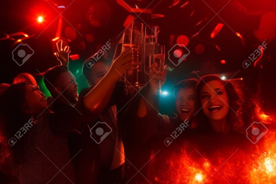 I giovani amichevoli brindando in night-club