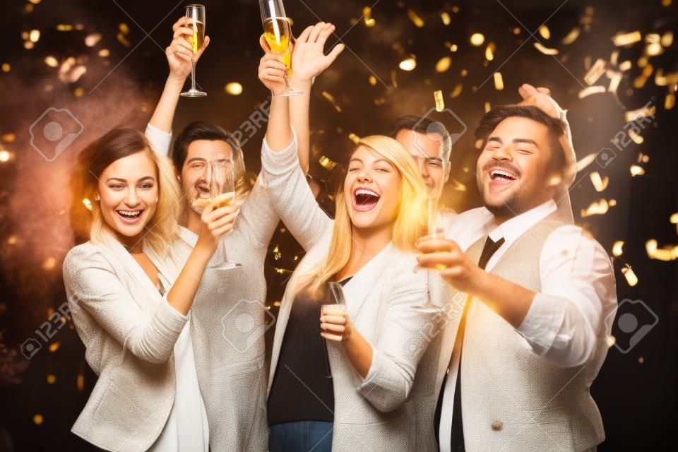 Gente alegre brindando con champán en la fiesta