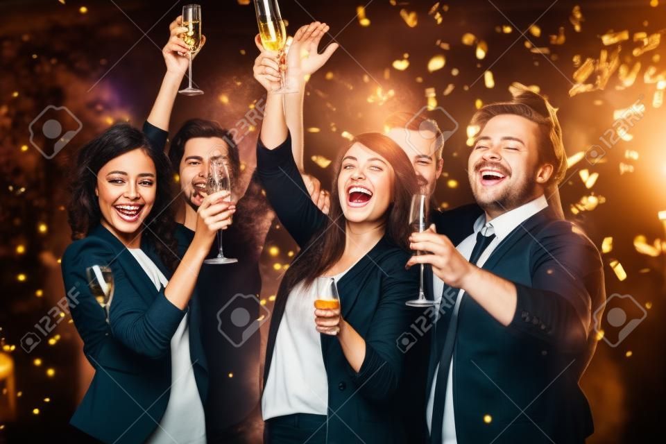 Gente alegre brindando con champán en la fiesta