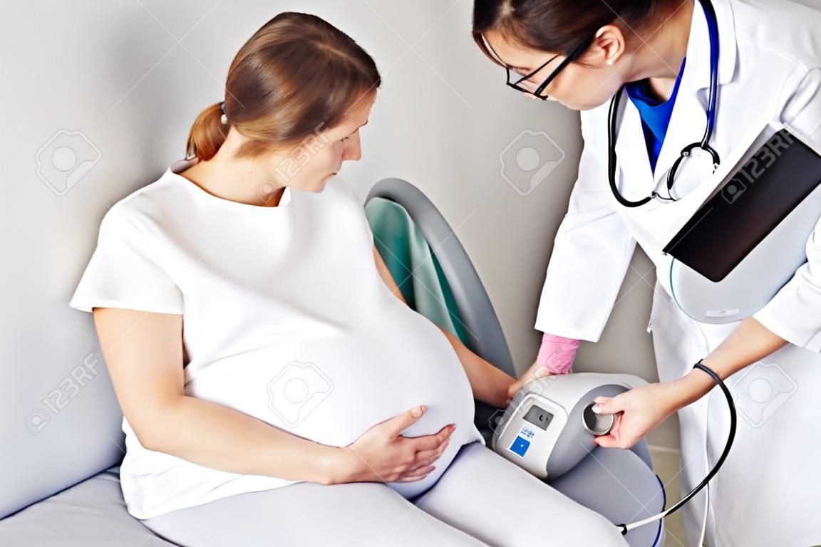 Médico medindo a pressão da mulher grávida no hospital