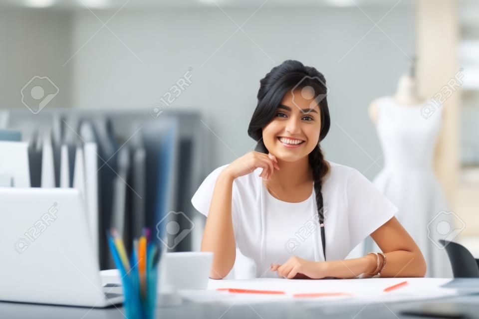Young designer at the workplace smiling and looking at camera