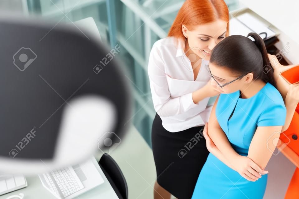 Two females gossiping in office