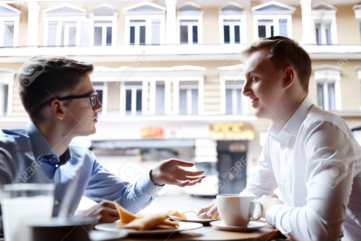I giovani imprenditori che parlano in pausa pranzo nella caffetteria