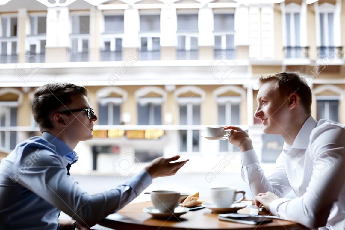 I giovani imprenditori che parlano in pausa pranzo nella caffetteria