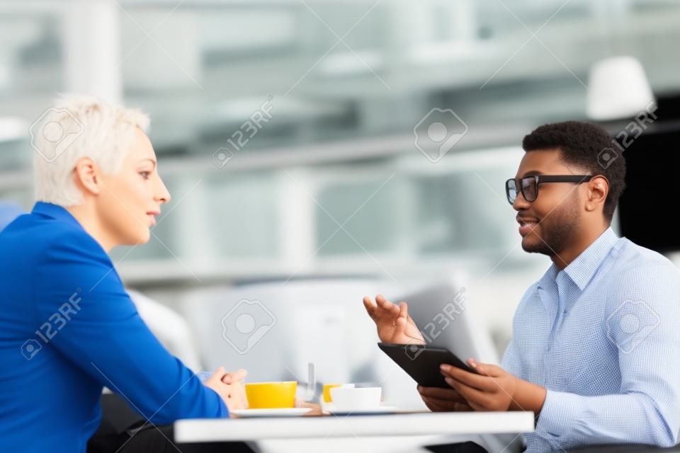 Business conversation of two co-workers at lunch break