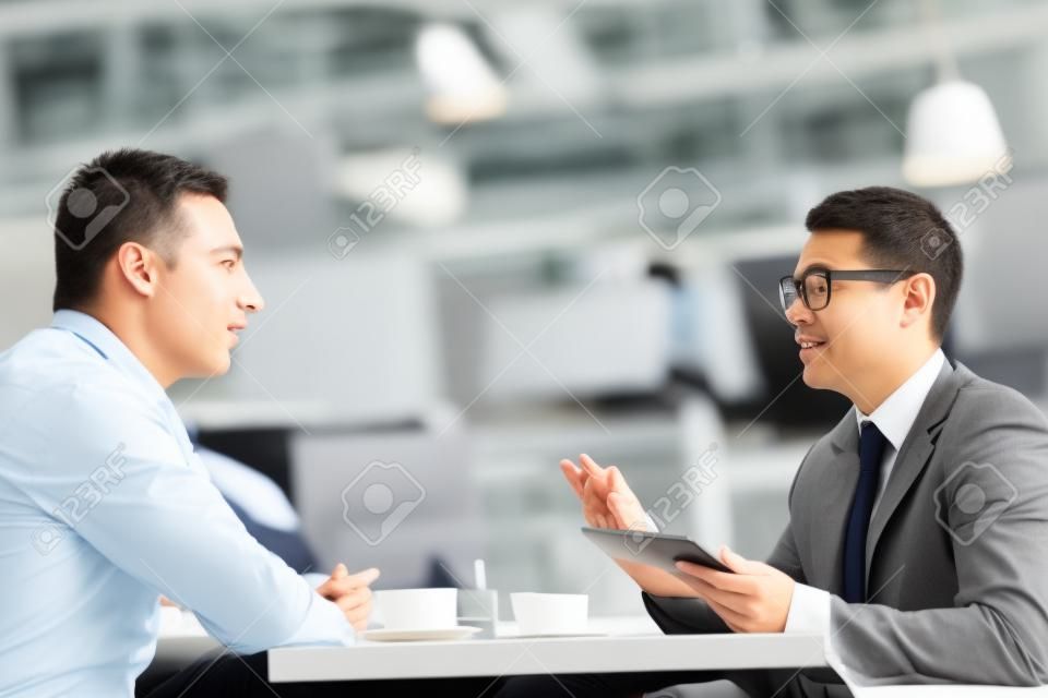 Business conversation of two co-workers at lunch break
