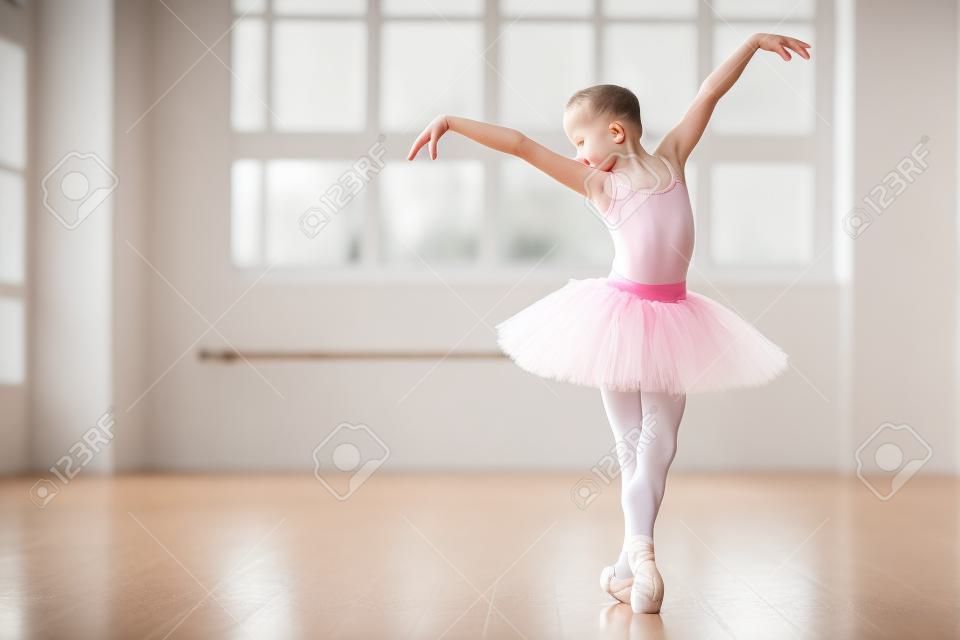 Kleine ballerina in tutu jurk oefenen tijdens de les op een klassiek ballet school