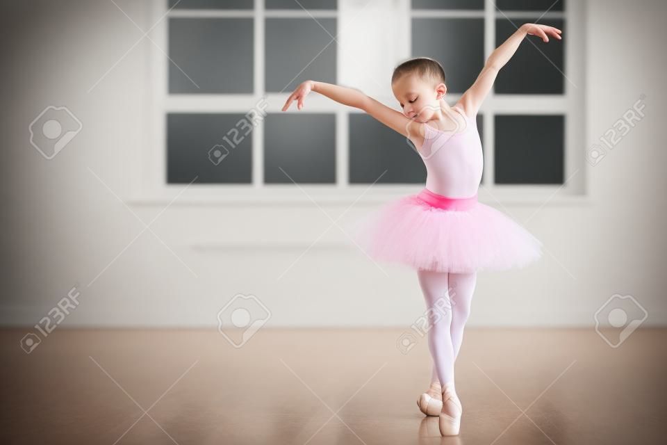 Kleine ballerina in tutu jurk oefenen tijdens de les op een klassiek ballet school