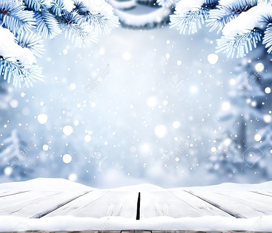 Winter decorative Christmas background with bokeh lights, snowflakes and empty old wooden table. Christmas and Happy New Year blue background with snowflake. Winter landscape with falling snow and fir tree branches.