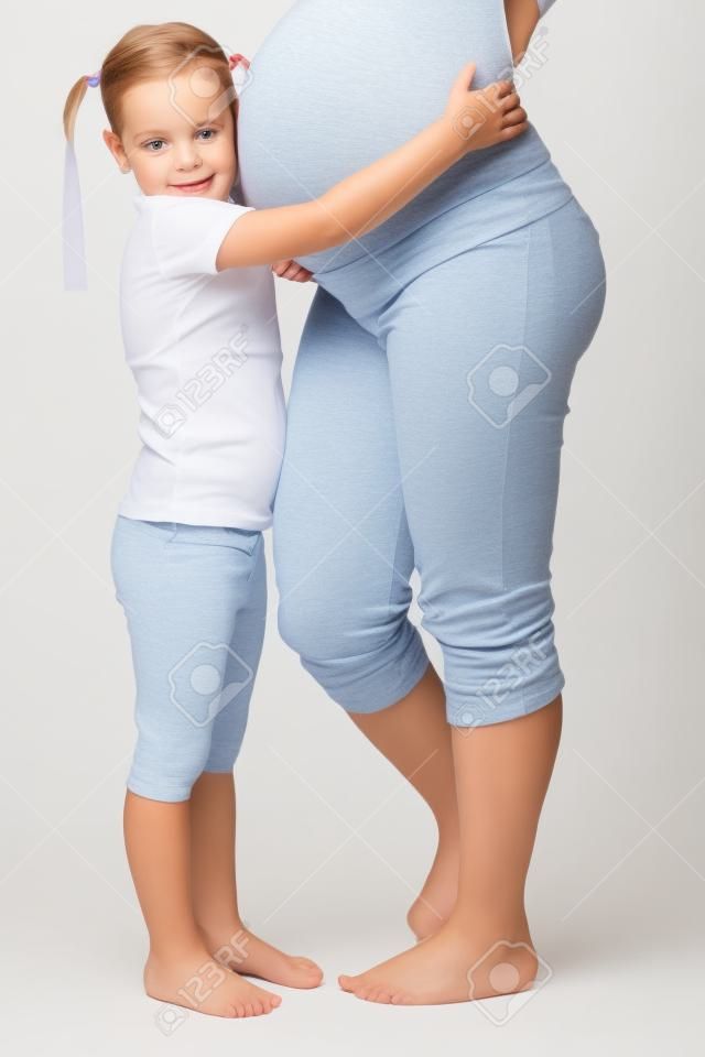 Belle femme enceinte avec sa fille. Isolé sur fond blanc