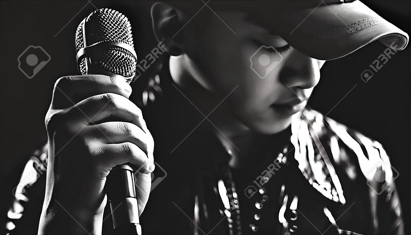 Les mains de chanteur asiatique sur le microphone, noir et blanc